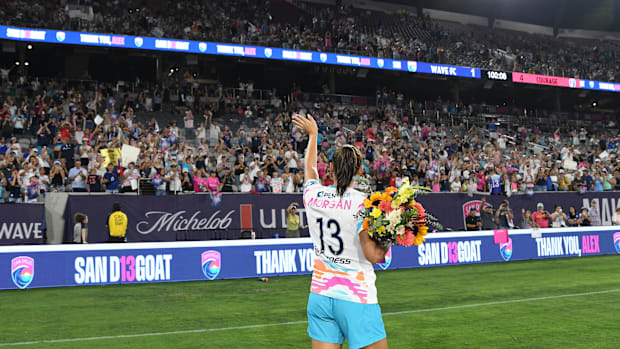 San Diego Wave forward Alex Morgan waves to fans while walking off the pitch following her final match