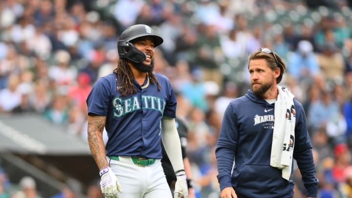 Seattle Mariners shortstop J.P. Crawford (3) walks to first base with trainer Kyle Torgerson after being hit by a pitch during the first inning against the Los Angeles Angels at T-Mobile Park on July 22.