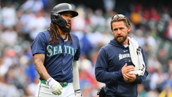 Seattle Mariners shortstop JP Crawford walks to first base with a trainer after being hit by a pitch against the Los Angeles Angels on July 22 at T-Mobile Park.