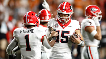 Carson Beck #15 and Trevor Etienne #1 of the Georgia Bulldogs celebrate after defeating the Texas Longhorns 30-15 at Darrell K Royal-Texas Memorial Stadium on October 19, 2024 in Austin, Texas.