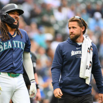 Seattle Mariners shortstop JP Crawford walks to first base with trainer Kyle Torgerson after being hit by a pitch on Monday against the Los Angeles Angels.