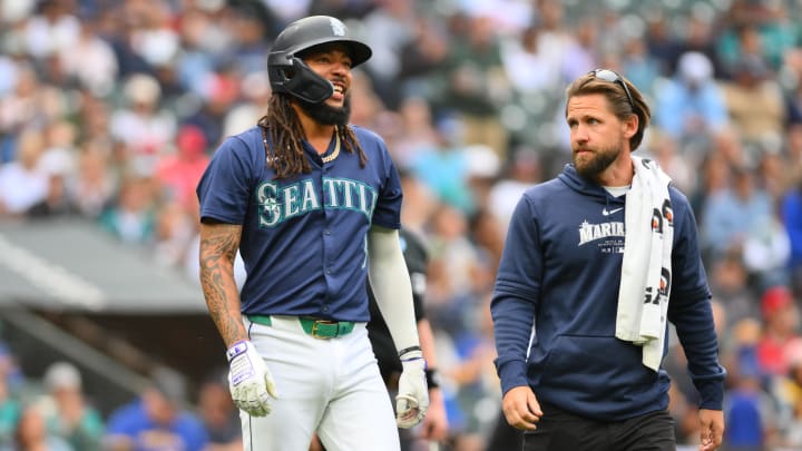 Seattle Mariners shortstop JP Crawford walks to first base with trainer Kyle Torgerson after being hit by a pitch on Monday against the Los Angeles Angels.