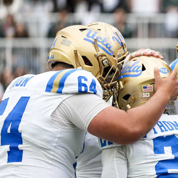 Oct 11, 2025; East Lansing, Michigan, USA; UCLA Bruins offensive linemen celebrate a touchdown with running back Jaivian Thomas (21) in the third quarter at Spartan Stadium. Mandatory Credit: Brendan Mullin-Imagn Images