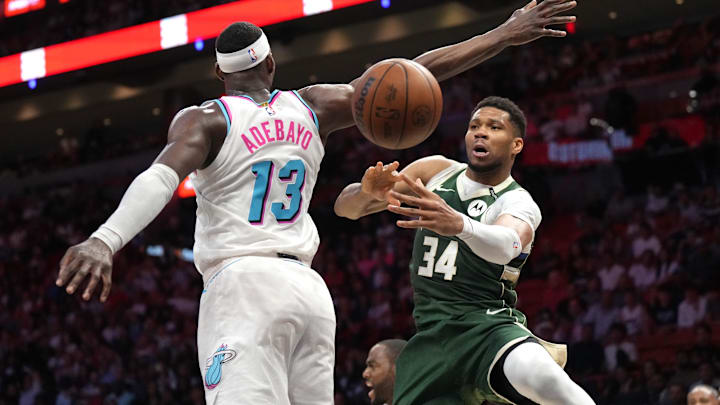 Apr 5, 2025; Miami, Florida, USA; Milwaukee Bucks forward Giannis Antetokounmpo (34) passes the ball under the arm of Miami Heat center Bam Adebayo (13) during overtime at Kaseya Center. Mandatory Credit: Jim Rassol-Imagn Images