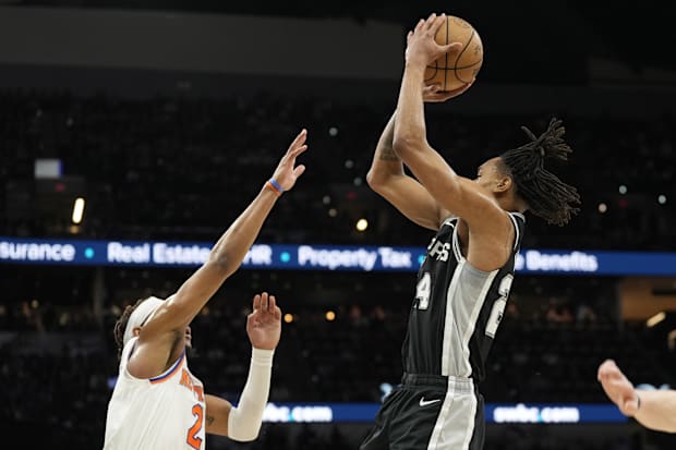 San Antonio Spurs guard Devin Vassell (24) shoots over New York Knicks guard Miles McBride (2).