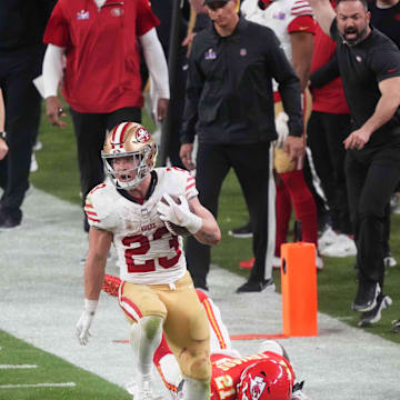 San Francisco 49ers running back Christian McCaffrey (23) runs with the ball against Kansas City Chiefs safety Mike Edwards (21) during overtime of Super Bowl LVIII at Allegiant Stadium in Paradise, Nev., on Feb. 11, 2024.