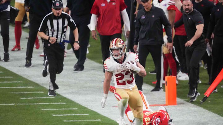 San Francisco 49ers running back Christian McCaffrey (23) runs with the ball against Kansas City Chiefs safety Mike Edwards (21) during overtime of Super Bowl LVIII at Allegiant Stadium in Paradise, Nev., on Feb. 11, 2024.