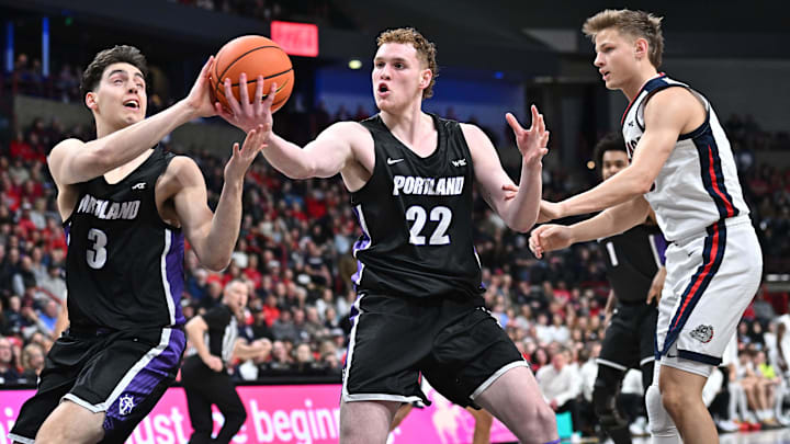 Jan 2, 2025; Spokane, Washington, USA; Portland Pilots forward Austin Rapp (22) rebounds against Gonzaga Bulldogs forward Ben Gregg (33) in the first half at Spokane Veterans Memorial Arena. Mandatory Credit: James Snook-Imagn Images