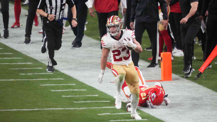 Feb 11, 2024; Paradise, Nevada, USA; San Francisco 49ers running back Christian McCaffrey (23) runs with the ball against Kansas City Chiefs safety Mike Edwards (21) during overtime of Super Bowl LVIII at Allegiant Stadium. Mandatory Credit: Joe Camporeale-USA TODAY Sports