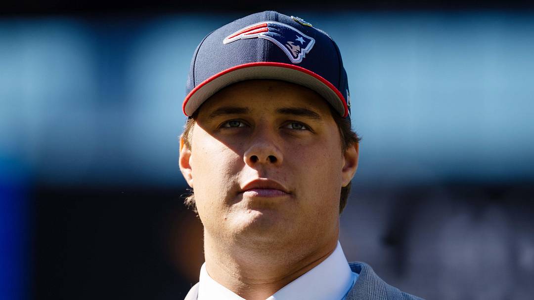 New England Patriots first-round draft pick Caleb Lomu walks to the podium during a press conference.