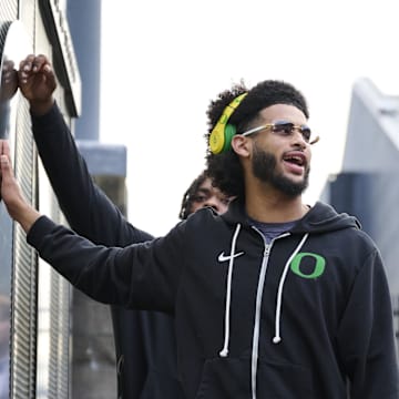 Nov 14, 2025; Eugene, Oregon, USA; Oregon Ducks quarterback Dante Moore (5) swipes his hand over the letter “O” during the “March to Victory” team walk before a game against the Minnesota Golden Gophers at Autzen Stadium. 