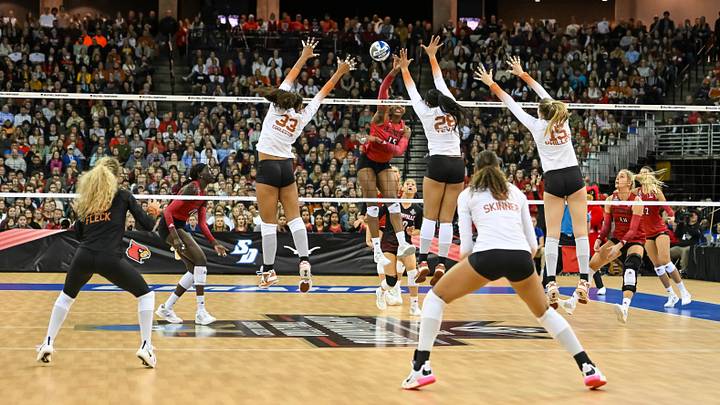 Dec 17, 2022; Omaha, Nebraska, US;  Louisville Cardinals Aiko Jones (15) attacks against Texas Longhorns Kayla Caffey (28) and Logan Eggleston (33) at CHI Health Center. Mandatory Credit: Steven Branscombe-USA TODAY Sports