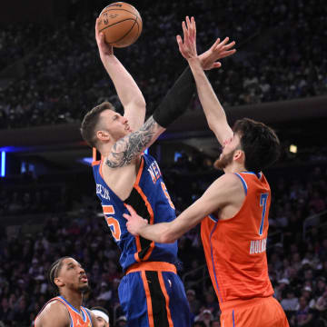 Mar 31, 2024; New York, New York, USA; New York Knicks center Isaiah Hartenstein (55) shoots the ball while being defended by Oklahoma City Thunder forward Chet Holmgren (7) and Oklahoma City Thunder guard Aaron Wiggins (21) during the second quarter at Madison Square Garden. Mandatory Credit: John Jones-USA TODAY Sports