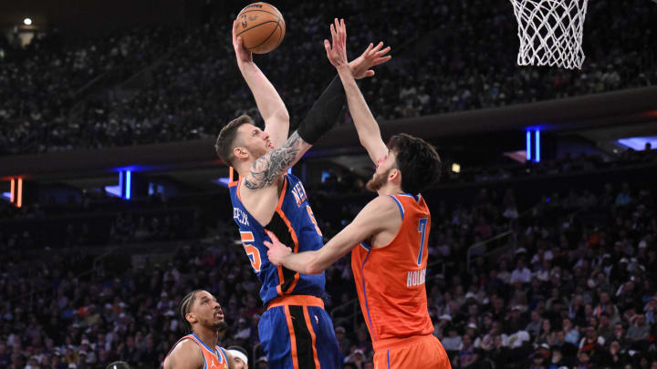 Mar 31, 2024; New York, New York, USA; New York Knicks center Isaiah Hartenstein (55) shoots the ball while being defended by Oklahoma City Thunder forward Chet Holmgren (7) and Oklahoma City Thunder guard Aaron Wiggins (21) during the second quarter at Madison Square Garden. Mandatory Credit: John Jones-USA TODAY Sports