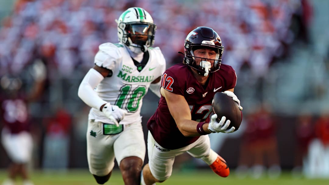 Sep 7, 2024; Blacksburg, Virginia, USA; Virginia Tech Hokies wide receiver Stephen Gosnell (12) dives for a catch against Marshall Thundering Herd cornerback Jacobie Henderson (10) during the second quarter at Lane Stadium. Mandatory Credit: Peter Casey-Imagn Images