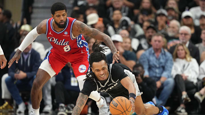 Apr 6, 2026; San Antonio, Texas, USA; San Antonio Spurs guard Stephon Castle (5) reaches for a loose ball ahead of Philadelphia 76ers forward Paul George (8) during the second half at Frost Bank Center. Mandatory Credit: Scott Wachter-Imagn Images