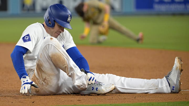 Sep 26, 2024; Los Angeles, California, USA;  Los Angeles Dodgers first baseman Freddie Freeman (5) grabs his ankle after he was injured during a play at first base in the seventh inning against the San Diego Padres at Dodger Stadium. Mandatory Credit: Jayne Kamin-Oncea-Imagn Images