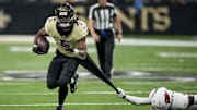 Sep 7, 2025; New Orleans, Louisiana, USA; New Orleans Saints running back Kendre Miller (5) rushes the bal as Arizona Cardinals cornerback Garrett Williams (21) attempts to tackle during the second quarter at Caesars Superdome. 