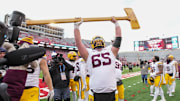 Nov 29, 2024; Madison, Wisconsin, USA;  Minnesota Golden Gophers offensive linenam Greg Johnson (65) celebrates with the Paul Bunyan Football Trophy following the game against the Wisconsin Badgers at Camp Randall Stadium. Mandatory Credit: Jeff Hanisch-Imagn Images