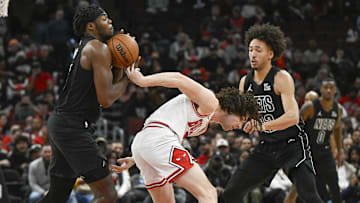 Dec 2, 2024; Chicago, Illinois, USA;  Chicago Bulls guard Josh Giddey (3) dribbles the ball behind his back while being guarded by Brooklyn Nets center Day'Ron Sharpe (20) and  forward Jalen Wilson (22) during the second half at the United Center. Mandatory Credit: Matt Marton-Imagn Images
