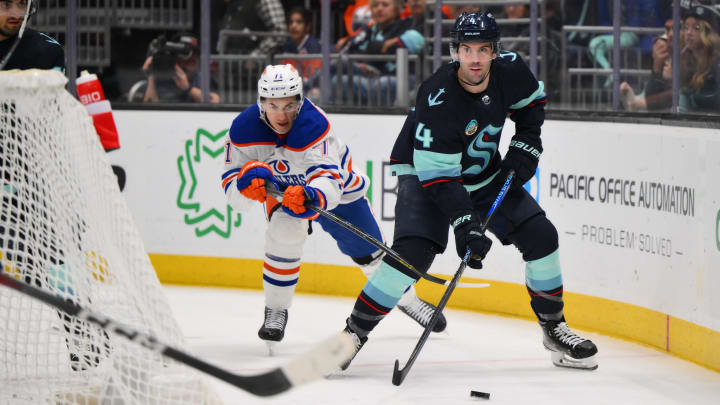 Mar 2, 2024; Seattle, Washington, USA; Seattle Kraken defenseman Justin Schultz (4) plays the puck while defended by Edmonton Oilers defenseman Vincent Desharnais (73) during the third period at Climate Pledge Arena. Mandatory Credit: Steven Bisig-USA TODAY Sports