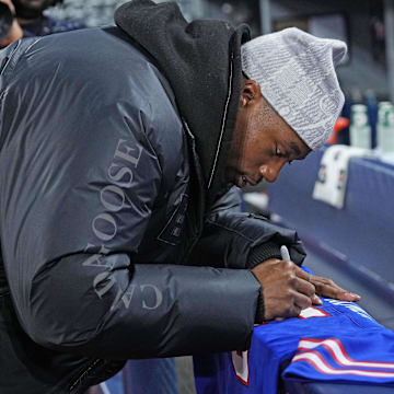 Buffalo Bills WR Joshua Palmer signs a jersey during batting practice before a game between the Baltimore Orioles and the Toronto Blue Jays.