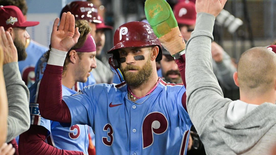 Oct 8, 2025; Los Angeles, California, USA; Philadelphia Phillies first baseman Bryce Harper (3) celebrates in the dugout after scoring on a Los Angeles Dodgers throwing error during the fourth inning during game three of the NLDS round for the 2025 MLB playoffs at Dodger Stadium. Mandatory Credit: Jayne Kamin-Oncea-Imagn Images