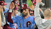 Oct 8, 2025; Los Angeles, California, USA; Philadelphia Phillies first baseman Bryce Harper (3) celebrates in the dugout after scoring on a Los Angeles Dodgers throwing error during the fourth inning during game three of the NLDS round for the 2025 MLB playoffs at Dodger Stadium. Mandatory Credit: Jayne Kamin-Oncea-Imagn Images
