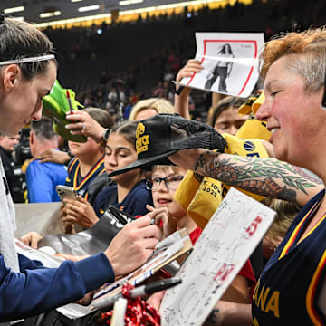 Indiana Fever guard Caitlin Clark (22) signs autographs for fans after the game against the Brazil National Team at Carver-Haweye Arena.