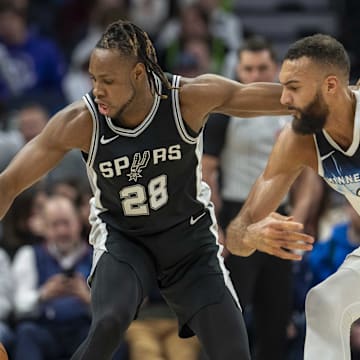 Dec 29, 2024; Minneapolis, Minnesota, USA; San Antonio Spurs center Charles Bassey (28) and Minnesota Timberwolves center Rudy Gobert (27) fight for a loose ball in the first half at Target Center.
