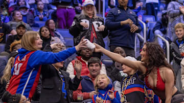 Dec 2, 2023; Detroit, Michigan, USA; A Pistons Dancer gives a fan a tee shirt during the second half