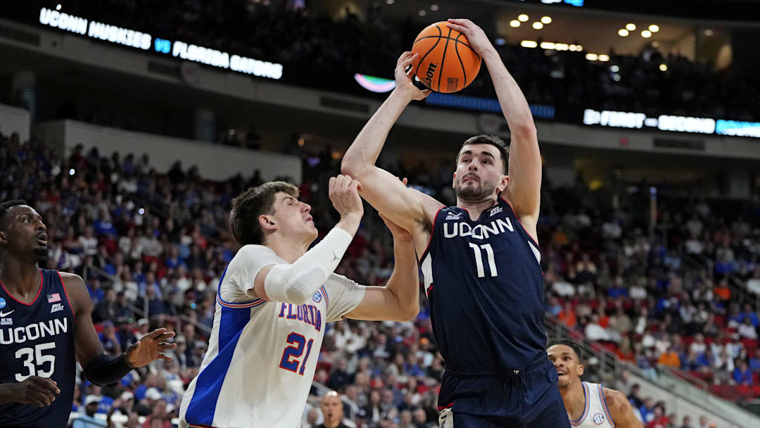 Mar 23, 2025; Raleigh, NC, USA; Connecticut Huskies forward Alex Karaban (11) drives to the basket as Florida Gators forward Alex Condon (21) defends during the first half in the second round of the NCAA Tournament at Lenovo Center. Mandatory Credit: Bob Donnan-Imagn Images Mar 23, 2025; Raleigh, NC, USA; Connecticut Huskies forward Alex Karaban (11) drives to the basket as Florida Gators forward Alex Condon (21) defends during the first half in the second round of the NCAA Tournament at Lenovo Center. Mandatory Credit: Bob Donnan-Imagn Images