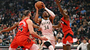 Oct 24, 2025; Toronto, Ontario, CAN; Milwaukee Bucks forward Giannis Antetokounmpo (34) is defended by Toronto Raptors forward Sandro Mamukelashvili (54) and guard Immanuel Quickley (5) in the first quarter at Scotiabank Arena. Mandatory Credit: Gerry Angus-Imagn Images