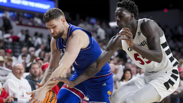 Jan 11, 2025; Cincinnati, Ohio, USA;  Kansas Jayhawks center Hunter Dickinson (1) battles for the loose ball against Cincinnati Bearcats forward Aziz Bandaogo (55) in the second half at Fifth Third Arena. Mandatory Credit: Aaron Doster-Imagn Images