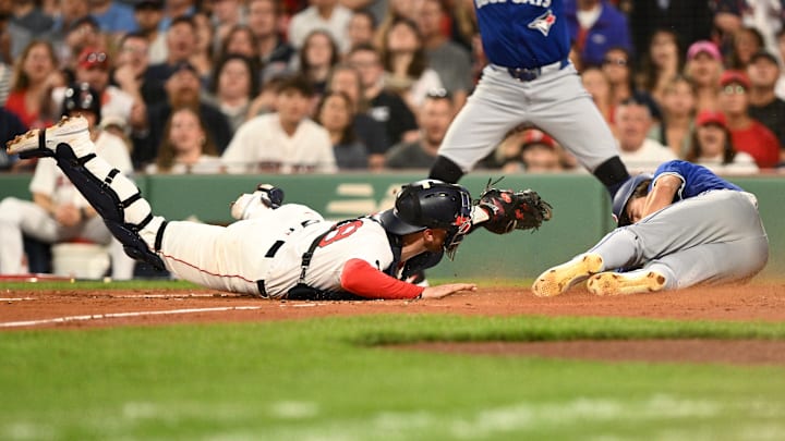 Aug 27, 2024; Boston, Massachusetts, USA; Boston Red Sox catcher Danny Jansen (28) tags out Toronto Blue Jays left fielder Joey Loperfido (9) at home during the second inning at Fenway Park. Mandatory Credit: Brian Fluharty-Imagn Images