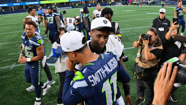 Las Vegas Raiders quarterback Geno Smith (7) and Seattle Seahawks wide receiver Jaxon Smith-Njigba (11) hug after the game at