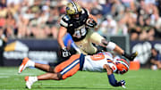 Oct 4, 2025; West Lafayette, Indiana, USA; Purdue Boilermakers running back Devin Mockobee (45) jumps over Illinois Fighting Illini defensive back Miles Scott (10) during the first quarter at Ross-Ade Stadium. Mandatory Credit: Marc Lebryk-Imagn Images