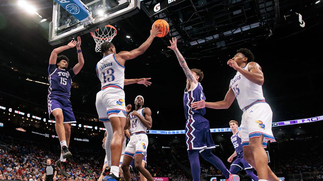 Mar 12, 2026; Kansas City, MO, USA; Kansas Jayhawks guard Elmarko Jackson (13) passes the ball over TCU Horned Frogs guard Brock Harding (2) during the first half at T-Mobile Center. Mandatory Credit: William Purnell-Imagn Images