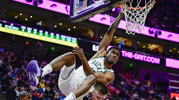 Mar 24, 2023; Salt Lake City, Utah, USA; Milwaukee Bucks forward Thanasis Antetokounmpo (43) hangs onto the rim after a dunk over Utah Jazz center Micah Potter (25) during the second half at Vivint Arena. Mandatory Credit: Christopher Creveling-Imagn Images