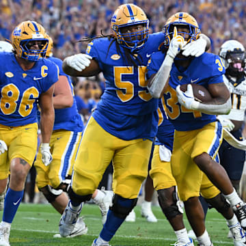 Sep 14, 2024; Pittsburgh, Pennsylvania, USA; Pittsburgh Panthers running back Derrick Davis Jr. (34) celebrates  a touchdown with BJ Williams (55) as West Virginia Mountaineers defensive lineman Fatorma Mulbah (54) looks on during the fourth quarter at Acrisure Stadium. Mandatory Credit: Barry Reeger-Image Images