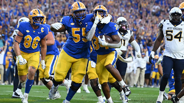 Sep 14, 2024; Pittsburgh, Pennsylvania, USA; Pittsburgh Panthers running back Derrick Davis Jr. (34) celebrates  a touchdown with BJ Williams (55) as West Virginia Mountaineers defensive lineman Fatorma Mulbah (54) looks on during the fourth quarter at Acrisure Stadium. Mandatory Credit: Barry Reeger-Image Images