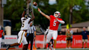 Milton quarterback Luke Nickel throws a pass against American Heritage defense 