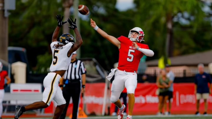 Milton quarterback Luke Nickel throws a pass against American Heritage defense 