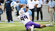 Sep 21, 2024; Chapel Hill, North Carolina, USA; North Carolina Tar Heels running back Omarion Hampton (28) is tackled by James Madison Dukes defensive lineman Eric O'Neill (99) in the second quarter at Kenan Memorial Stadium. Mandatory Credit: Bob Donnan-Imagn Images