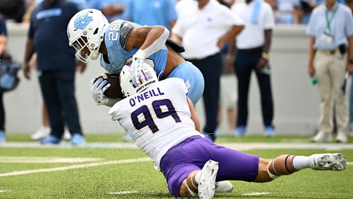 Sep 21, 2024; Chapel Hill, North Carolina, USA; North Carolina Tar Heels running back Omarion Hampton (28) is tackled by James Madison Dukes defensive lineman Eric O'Neill (99) in the second quarter at Kenan Memorial Stadium. Mandatory Credit: Bob Donnan-Imagn Images Sep 21, 2024; Chapel Hill, North Carolina, USA; North Carolina Tar Heels running back Omarion Hampton (28) is tackled by James Madison Dukes defensive lineman Eric O'Neill (99) in the second quarter at Kenan Memorial Stadium. Mandatory Credit: Bob Donnan-Imagn Images