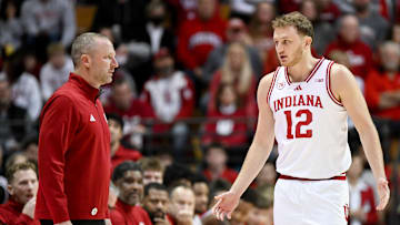 Nov 29, 2025; Bloomington, Indiana, USA; Indiana Hoosiers head coach Darian Devries and Indiana Hoosiers forward Tucker Devries (12) talk during the first half against the Bethune-Cookman Wildcats at Simon Skjodt Assembly Hall. Mandatory Credit: Robert Goddin-Imagn Images