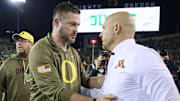 Nov 14, 2025; Eugene, Oregon, USA; Oregon Ducks head coach Dan Lanning, left, talks to Minnesota Golden Gophers head coach P.J. Fleck after a game at Autzen Stadium. 