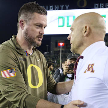 Nov 14, 2025; Eugene, Oregon, USA; Oregon Ducks head coach Dan Lanning, left, talks to Minnesota Golden Gophers head coach P.J. Fleck after a game at Autzen Stadium. 