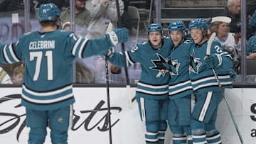 Mar 22, 2025; San Jose, California, USA;  San Jose Sharks defenseman Luca Cagnoni (42), left wing William Eklund (72) and center Will Smith (2) wait for teammate center Macklin Celebrini (71) to celebrate during the second period against the Boston Bruins at SAP Center at San Jose. Mandatory Credit: Stan Szeto-Imagn Images