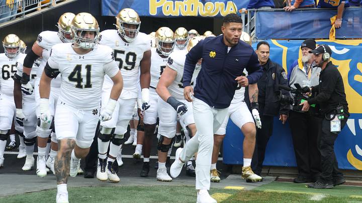 Nov 15, 2025; Pittsburgh, Pennsylvania, USA;  Notre Dame Fighting Irish head coach Marcus Freeman (right) leads the team onto the field to play the Pittsburgh Panthers at Acrisure Stadium. Mandatory Credit: Charles LeClaire-Imagn Images